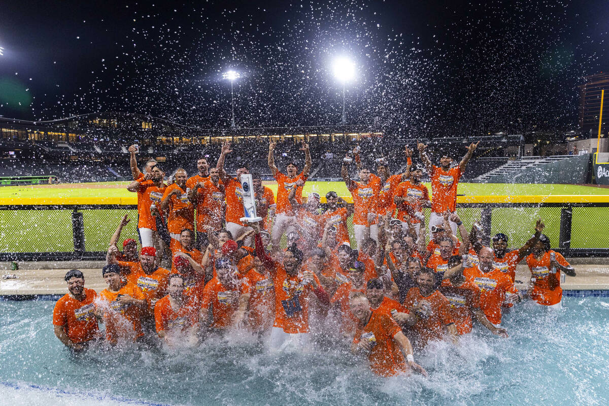 Aviators manager Fran Riordan joins his players with their trophy as they celebrate their win o ...