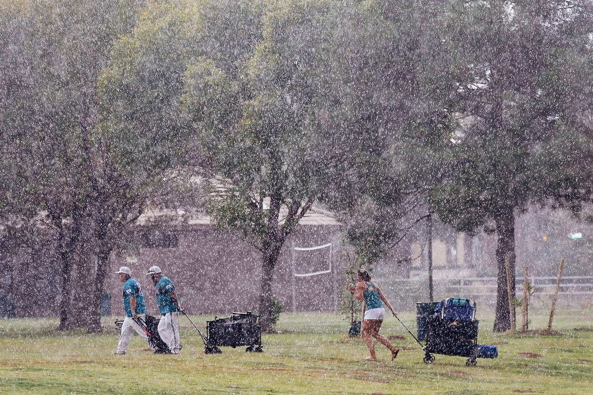 People hurry to their cars as rain comes down from a storm at Sunset Park Friday, Sept. 26, 202 ...