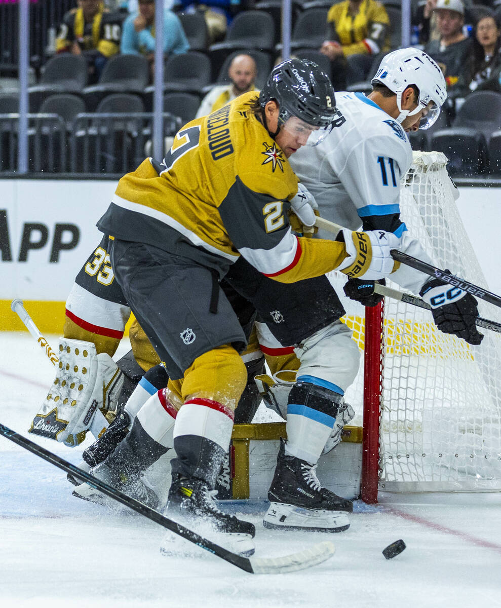 Utah Mammoth right wing Dylan Guenther (11) is driven off the puck by with Golden Knights defen ...