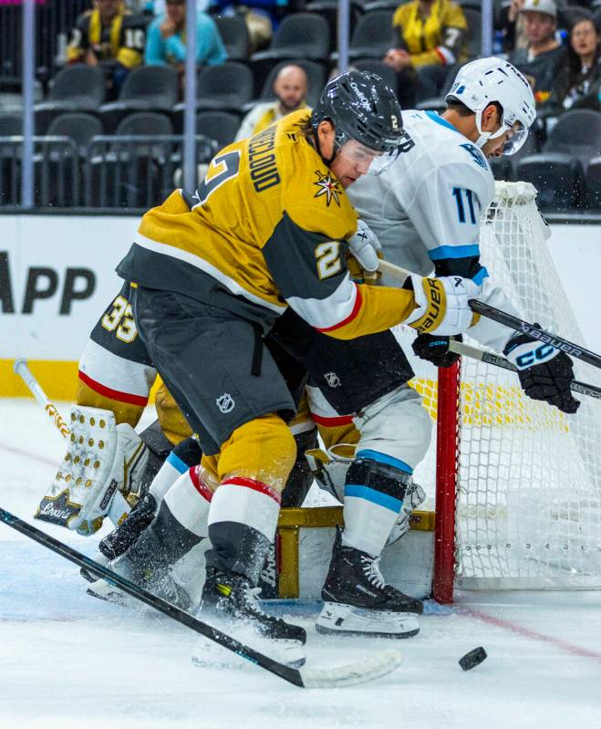 Utah Mammoth right wing Dylan Guenther (11) is driven off the puck by with Golden Knights defen ...