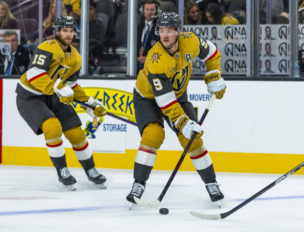 Golden Knights center Jack Eichel (9) looks to pass with defenseman Noah Hanifin (15) trailing ...