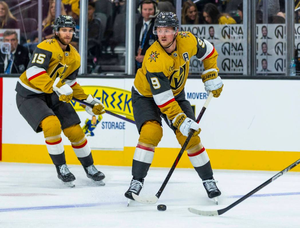 Golden Knights center Jack Eichel (9) looks to pass with defenseman Noah Hanifin (15) trailing ...