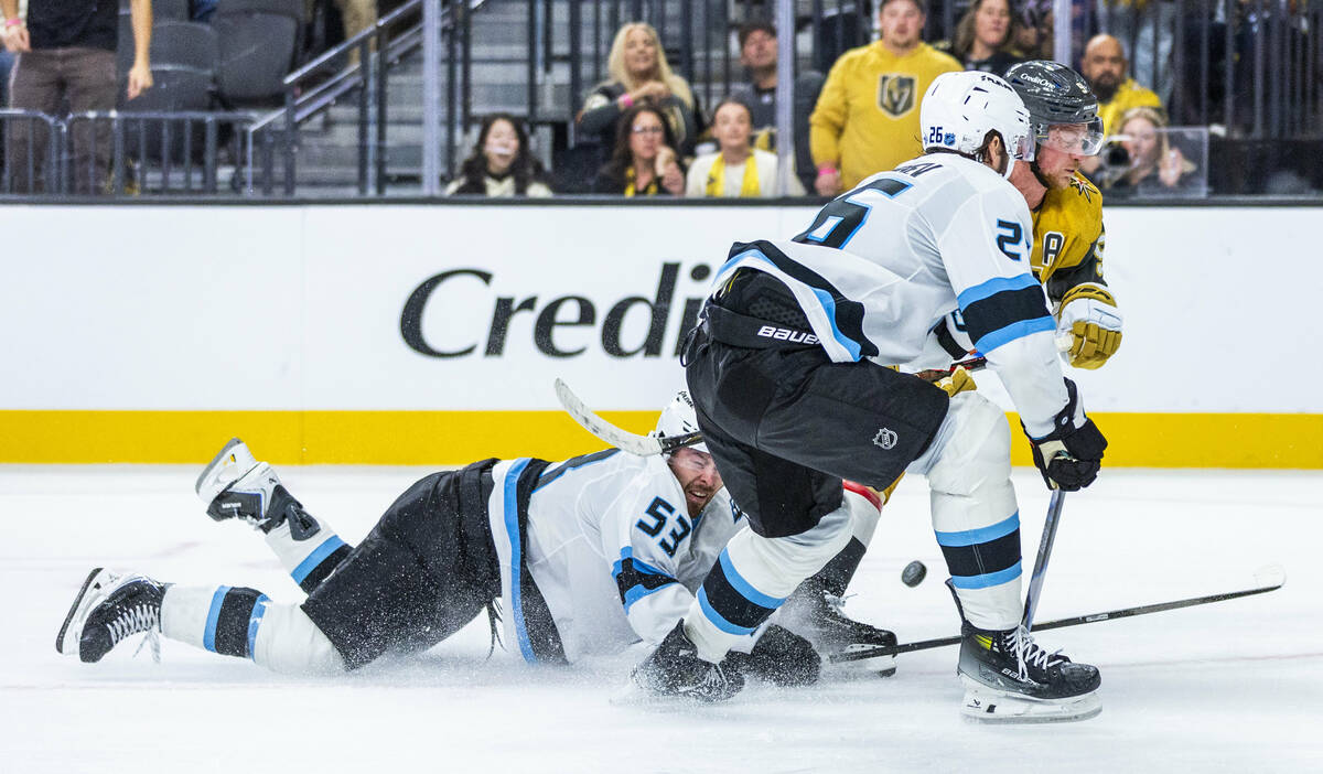 Utah Mammoth left wing Michael Carcone (53) falls to the ice after battling for the puck with G ...