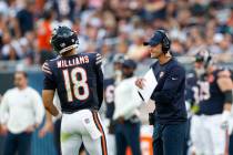 Chicago Bears head coach Ben Johnson, right, talks to quarterback Caleb Williams, left, during ...