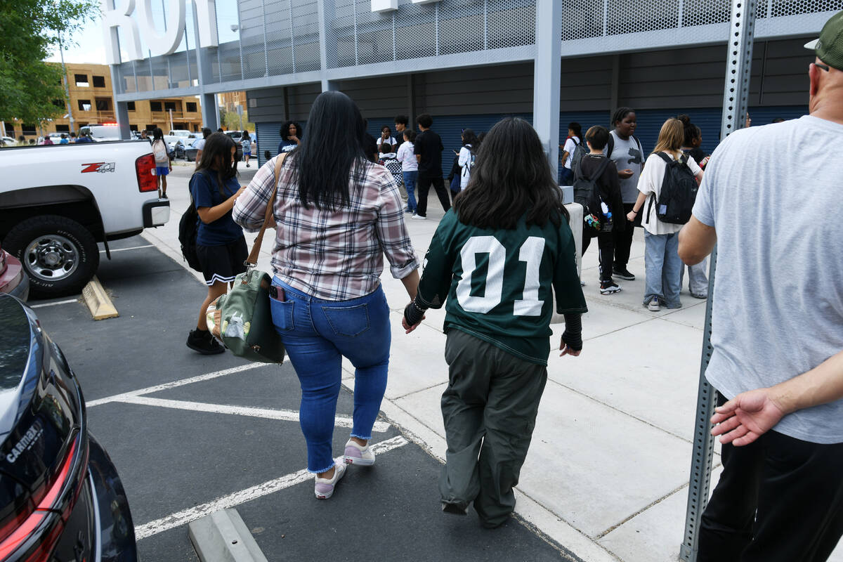 A woman and student walk away from school during a lockdown at Roy Martin Middle School Friday, ...