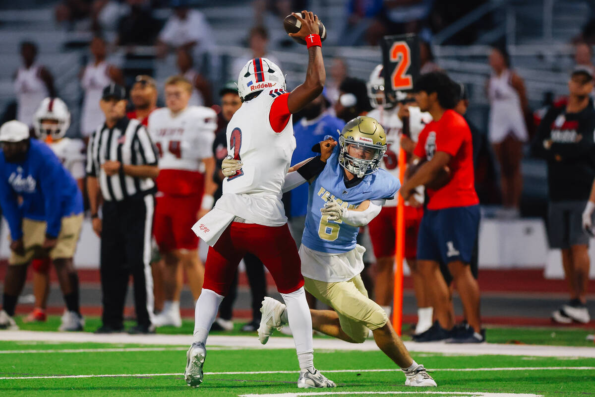 Foothill linebacker Baylor Petashiski (6) grabs hold of Liberty quarterback Ramiro Reinaldo (2) ...