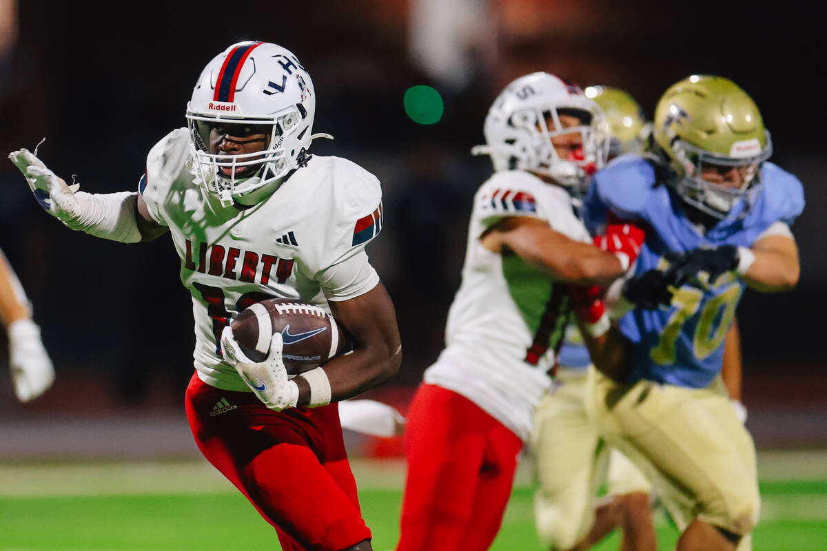 Liberty tight end Aiden Webster runs the ball during a high school football game between Libert ...