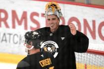 Pittsburgh Penguins goalie Marc-Andre Fleury, rear, has a laugh with Sidney Crosby during a bre ...