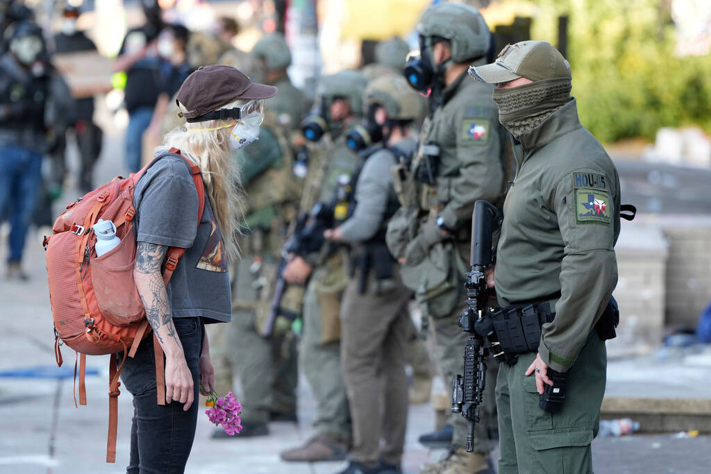 FILE - A woman stands off with a law enforcement officer wearing a Houston Field Office Special ...