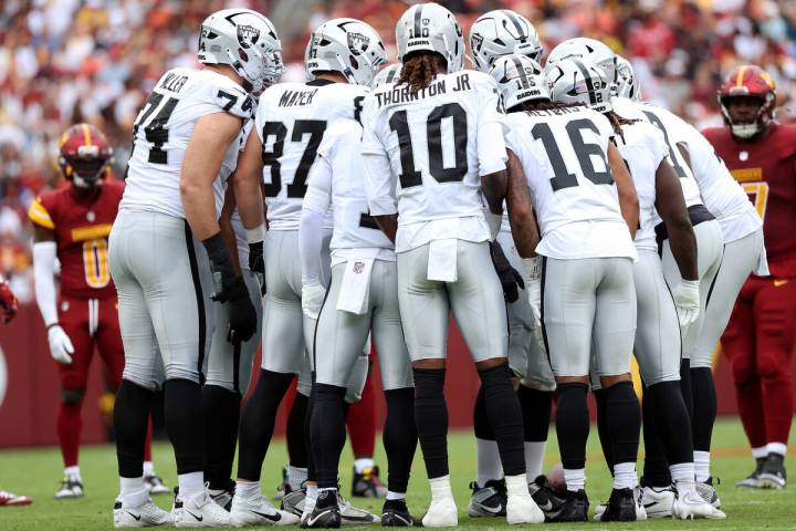 Las Vegas Raiders players huddle up during an NFL football game against the Washington Commande ...