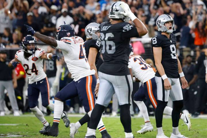Chicago Bears players celebrate while Raiders kicker Daniel Carlson (8) and defensive tackle Jo ...
