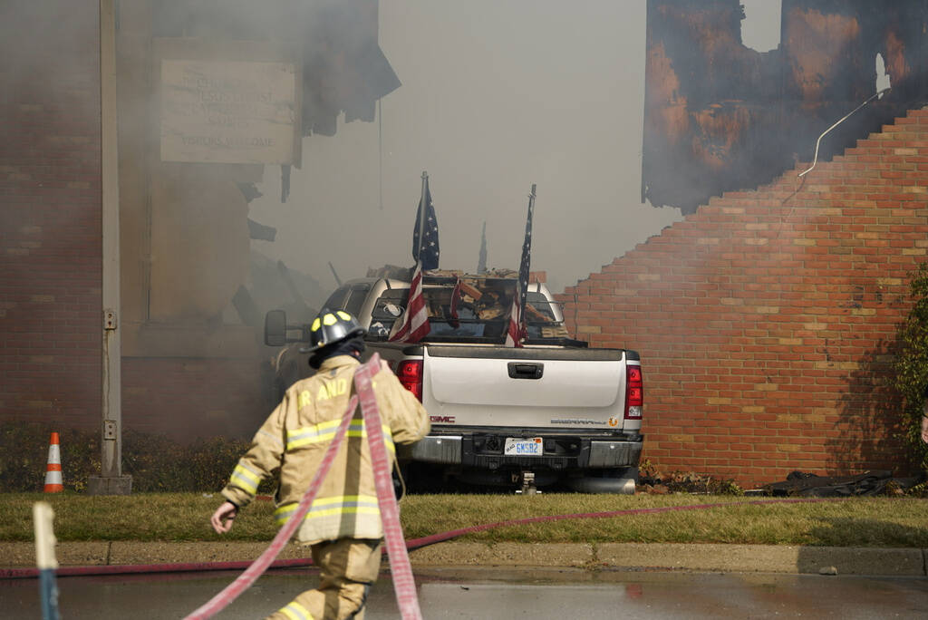Firefighters work on the scene of a fire and shooting at the Church of Jesus Christ of Latter-d ...