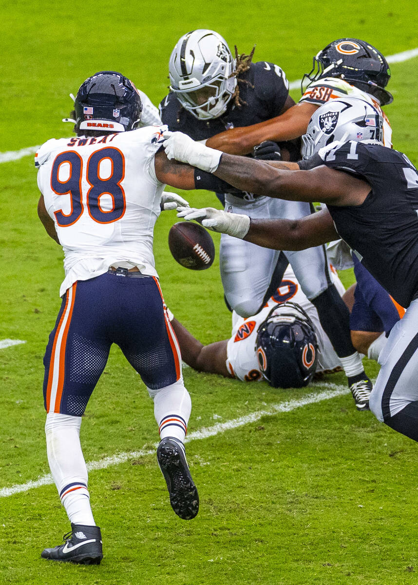 Raiders running back Ashton Jeanty (2) fumbles the ball as Chicago Bears defensive end Montez S ...