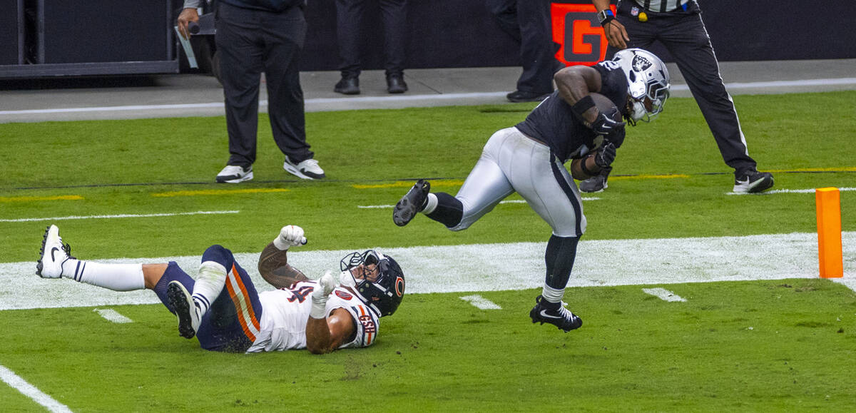 Raiders running back Ashton Jeanty (2) runs over Chicago Bears linebacker Noah Sewell (44) for ...