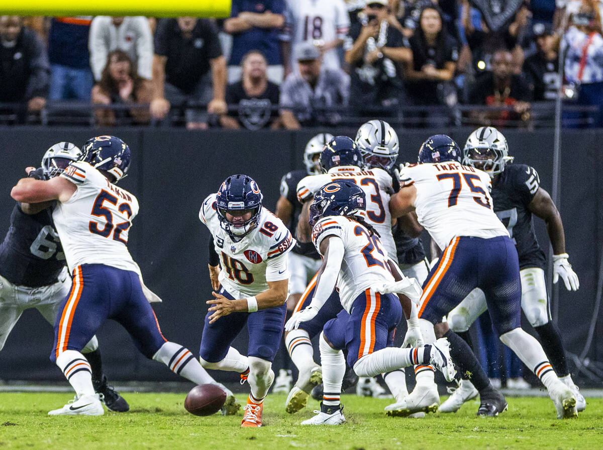 Chicago Bears quarterback Caleb Williams (18) eyes a loose ball hiked past him against the Raid ...