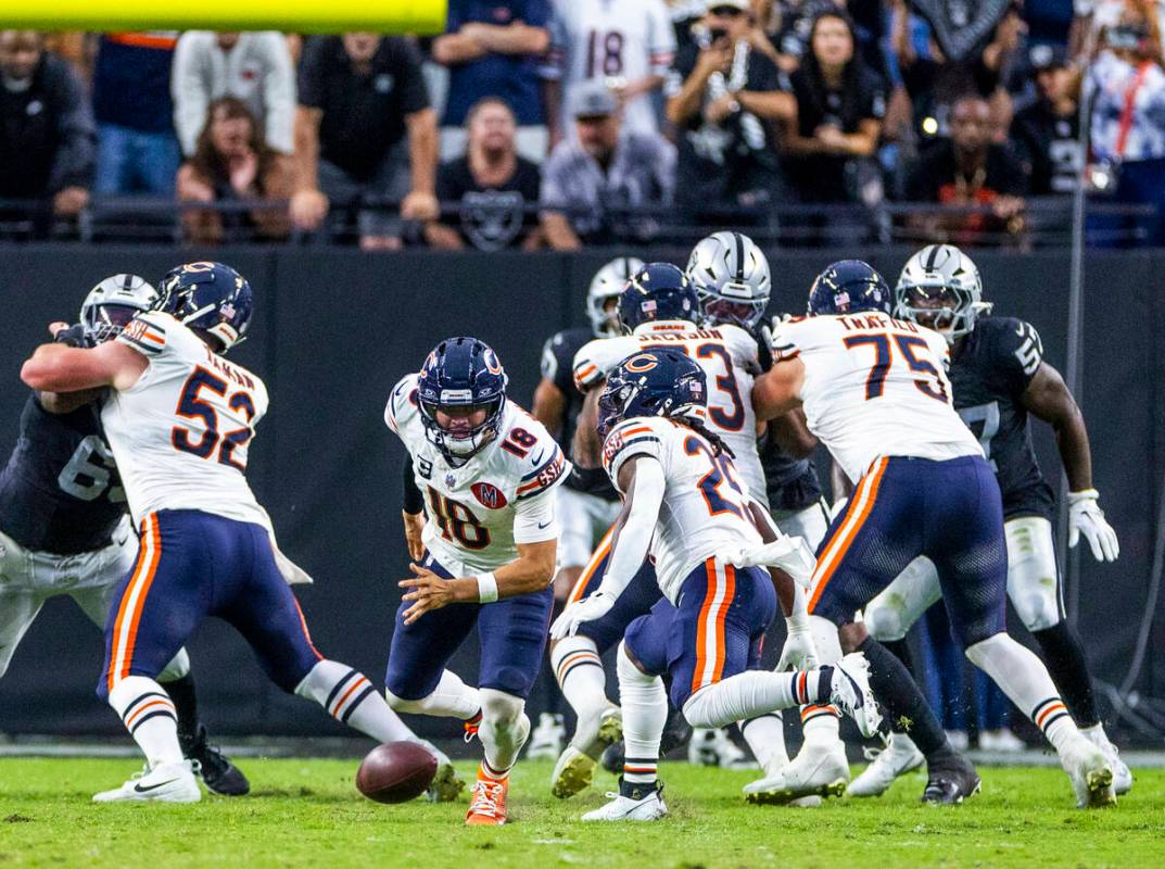 Chicago Bears quarterback Caleb Williams (18) eyes a loose ball hiked past him against the Raid ...