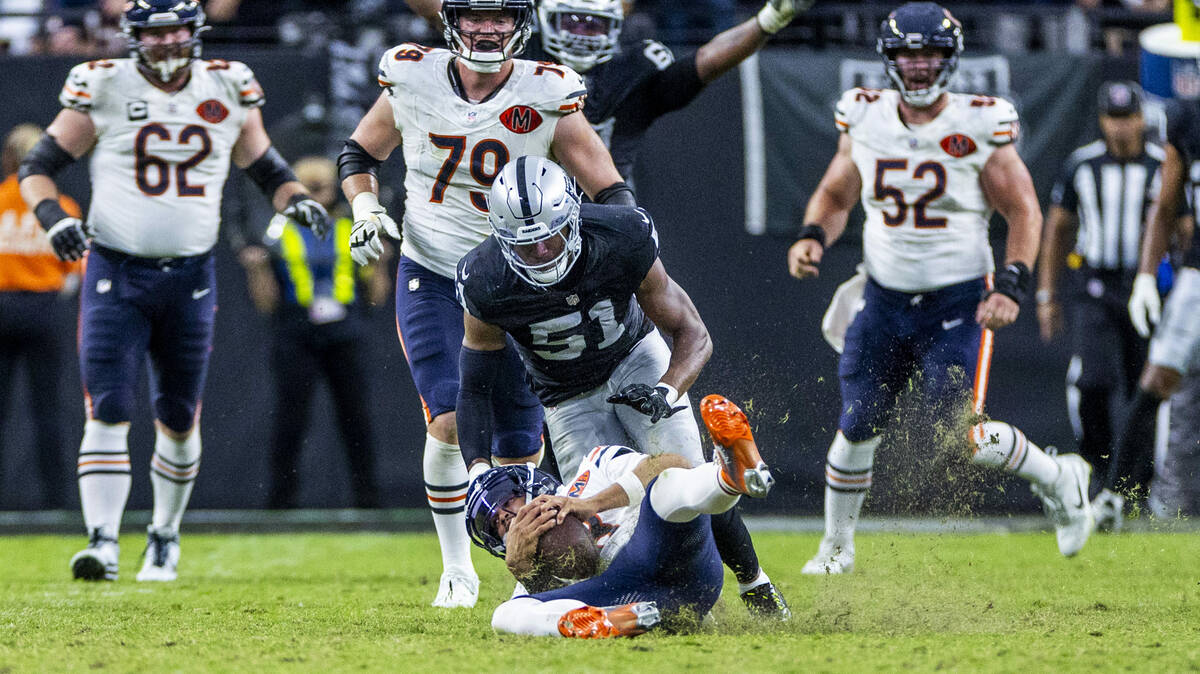 Chicago Bears quarterback Caleb Williams (18) secures a loose ball as Raiders defensive end Mal ...
