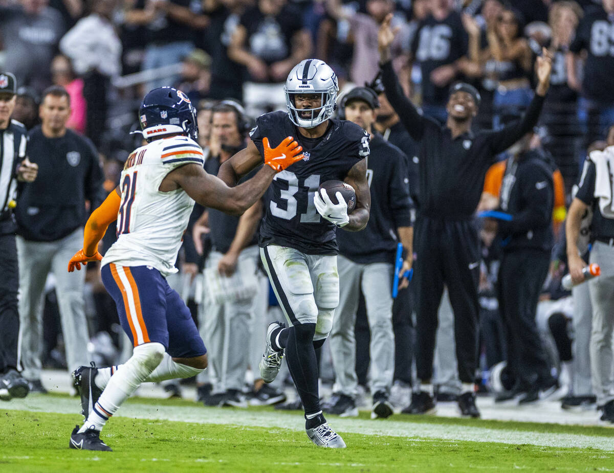 Raiders running back Raheem Mostert (31) looks to get past Chicago Bears free safety Kevin Byar ...