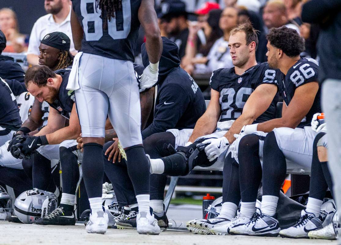 Raiders tight end Brock Bowers (89) checks his kneed while on the bench with teammates against ...