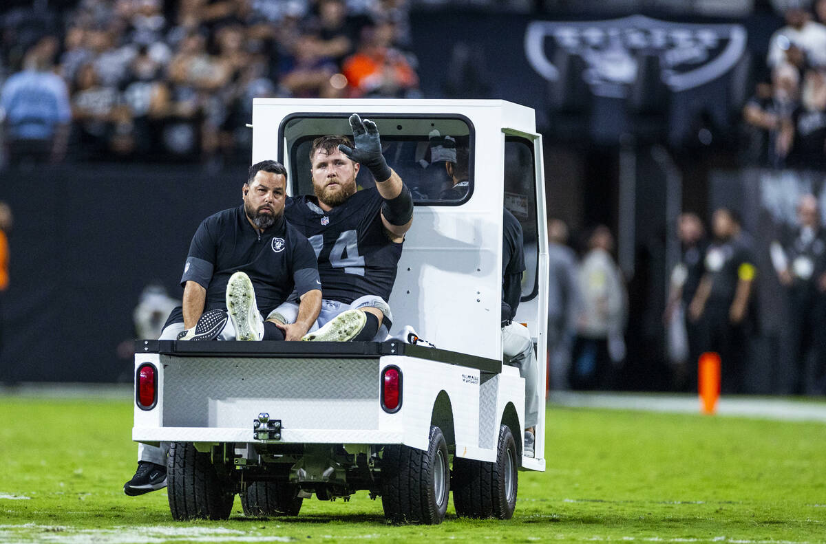 Raiders offensive tackle Kolton Miller (74) waves to the fans as he's carted off following ...