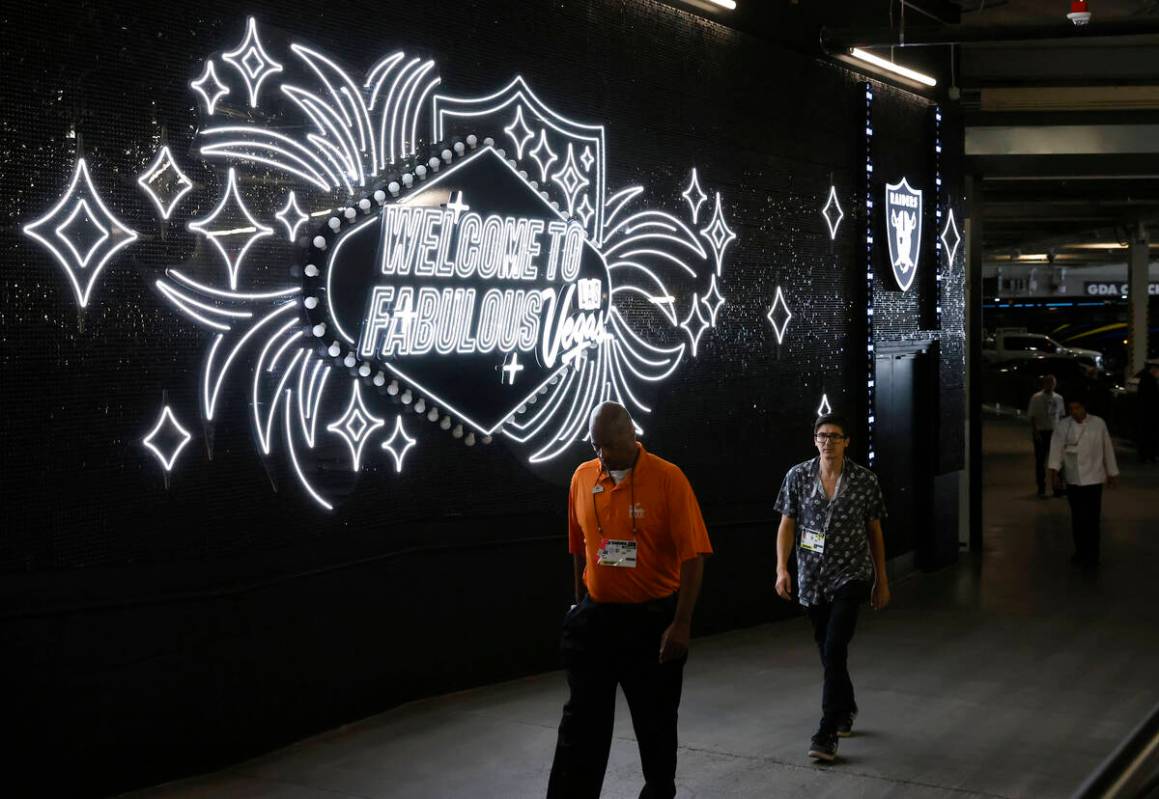 Workers walk throug the "Welcome to Fabulous Las Vegas" walk during an NFL football g ...