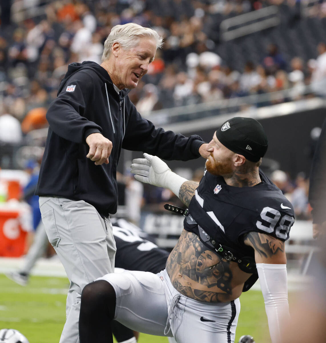 Raiders head coach Pete Carroll and defensive end Maxx Crosby (98) greet each other prior to an ...