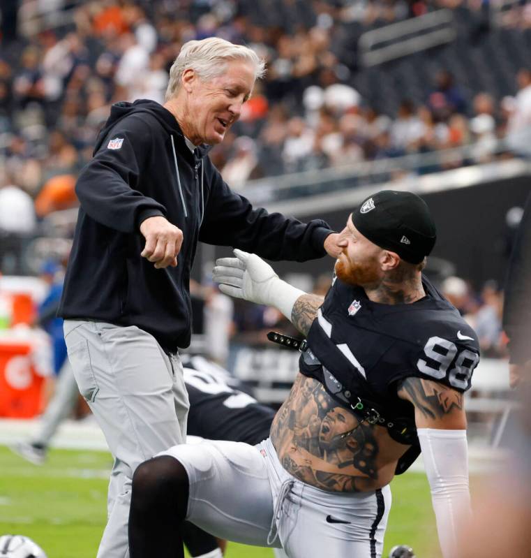 Raiders head coach Pete Carroll and defensive end Maxx Crosby (98) greet each other prior to an ...
