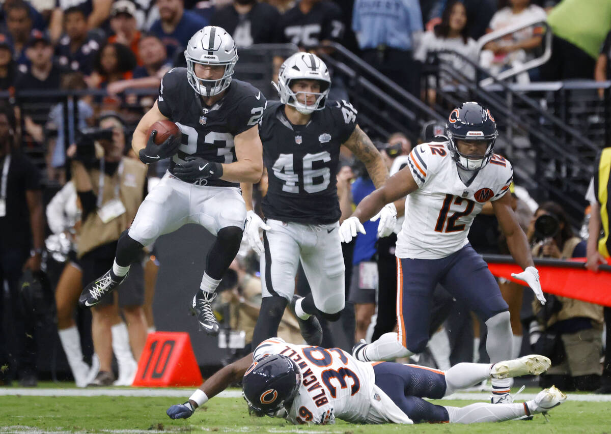 Raiders running back Dylan Laube (23) leaps over Chicago Bears cornerback Josh Blackwell (39) d ...