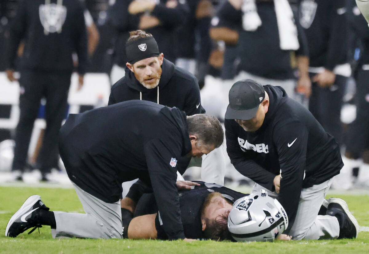 Raiders offensive tackle Kolton Miller (74) receives medical attention on the field after being ...