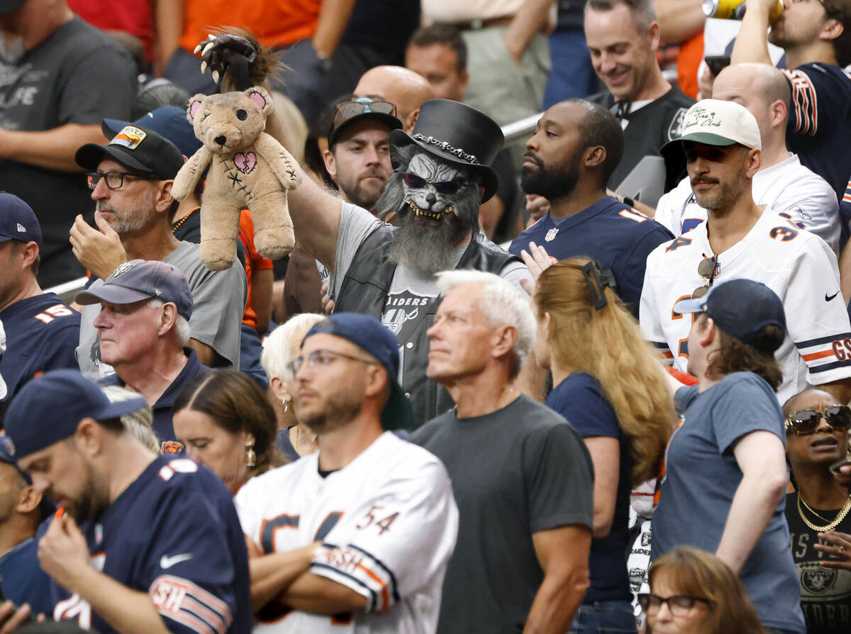 A sole Raiders fan displayes a teddy bear as he watches an NFL football game between Raiders an ...