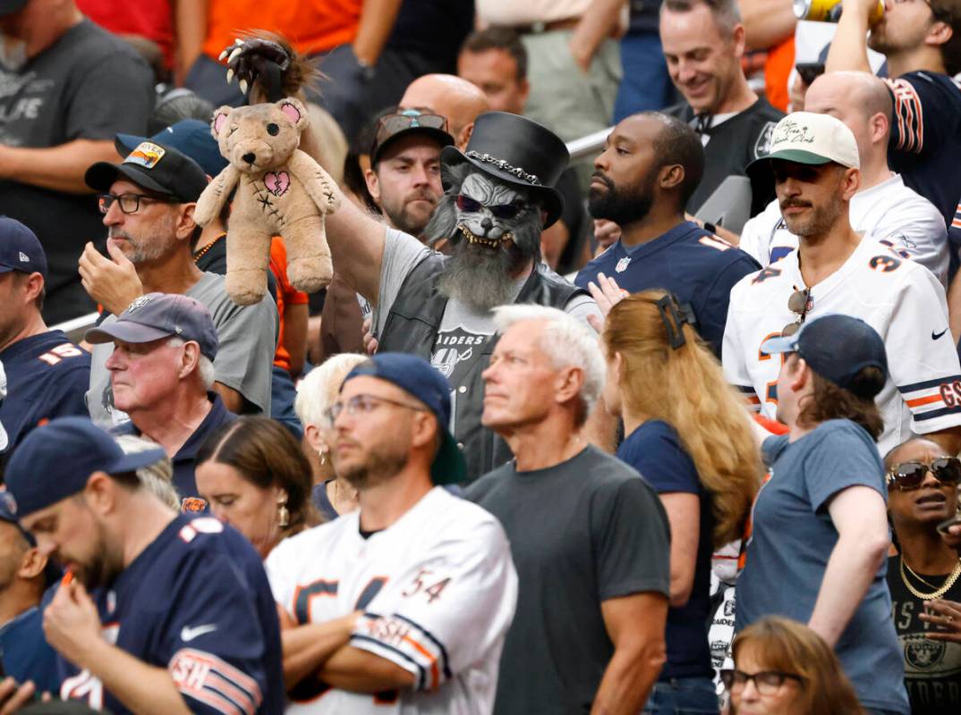 A sole Raiders fan displayes a teddy bear as he watches an NFL football game between Raiders an ...