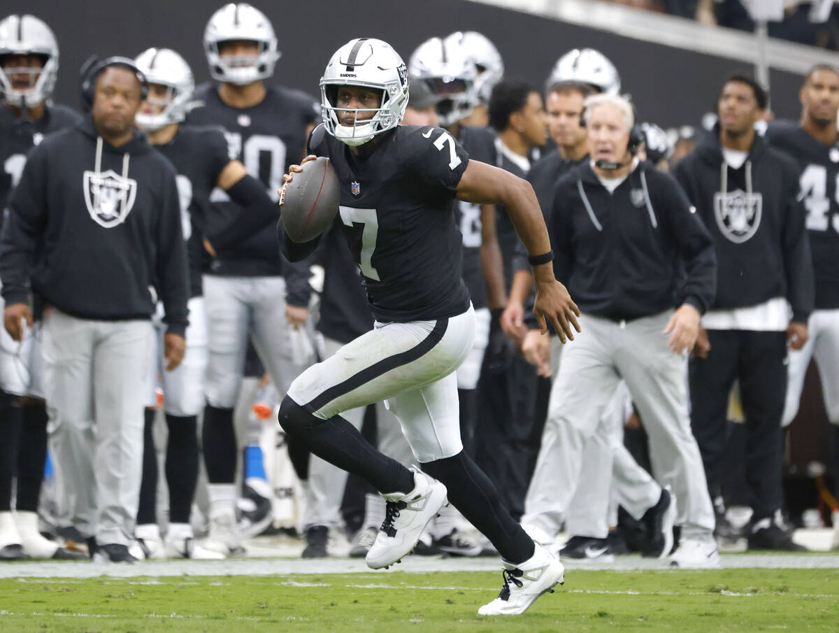 Raiders quarterback Geno Smith (7) runs with the ball for a first down during an NFL football g ...