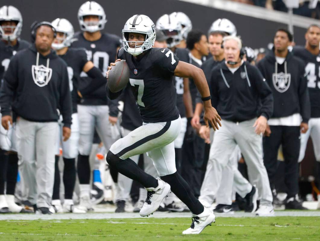 Raiders quarterback Geno Smith (7) runs with the ball for a first down during an NFL football g ...