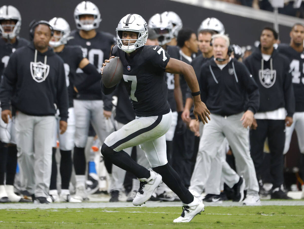 Raiders quarterback Geno Smith (7) runs with the ball for a first down during an NFL football g ...