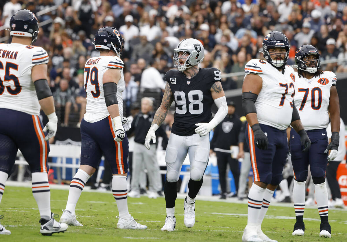 Chicago Bears players as watch as Raiders defensive end Maxx Crosby (98) reacts after blocking ...