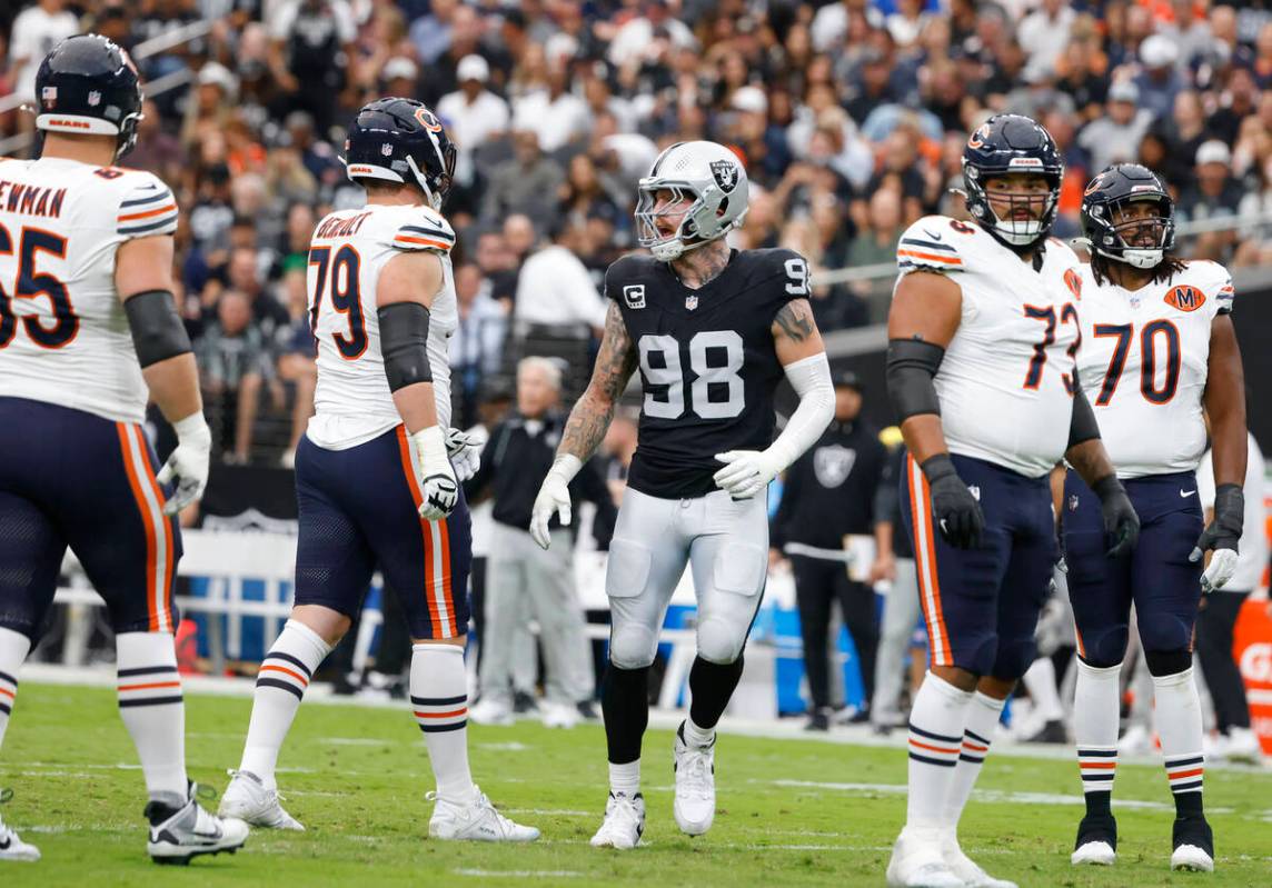 Chicago Bears players as watch as Raiders defensive end Maxx Crosby (98) reacts after blocking ...