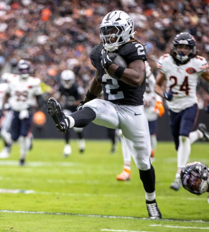 Raiders running back Ashton Jeanty (2) kicks his leg out after breaking a tackle against the Ch ...
