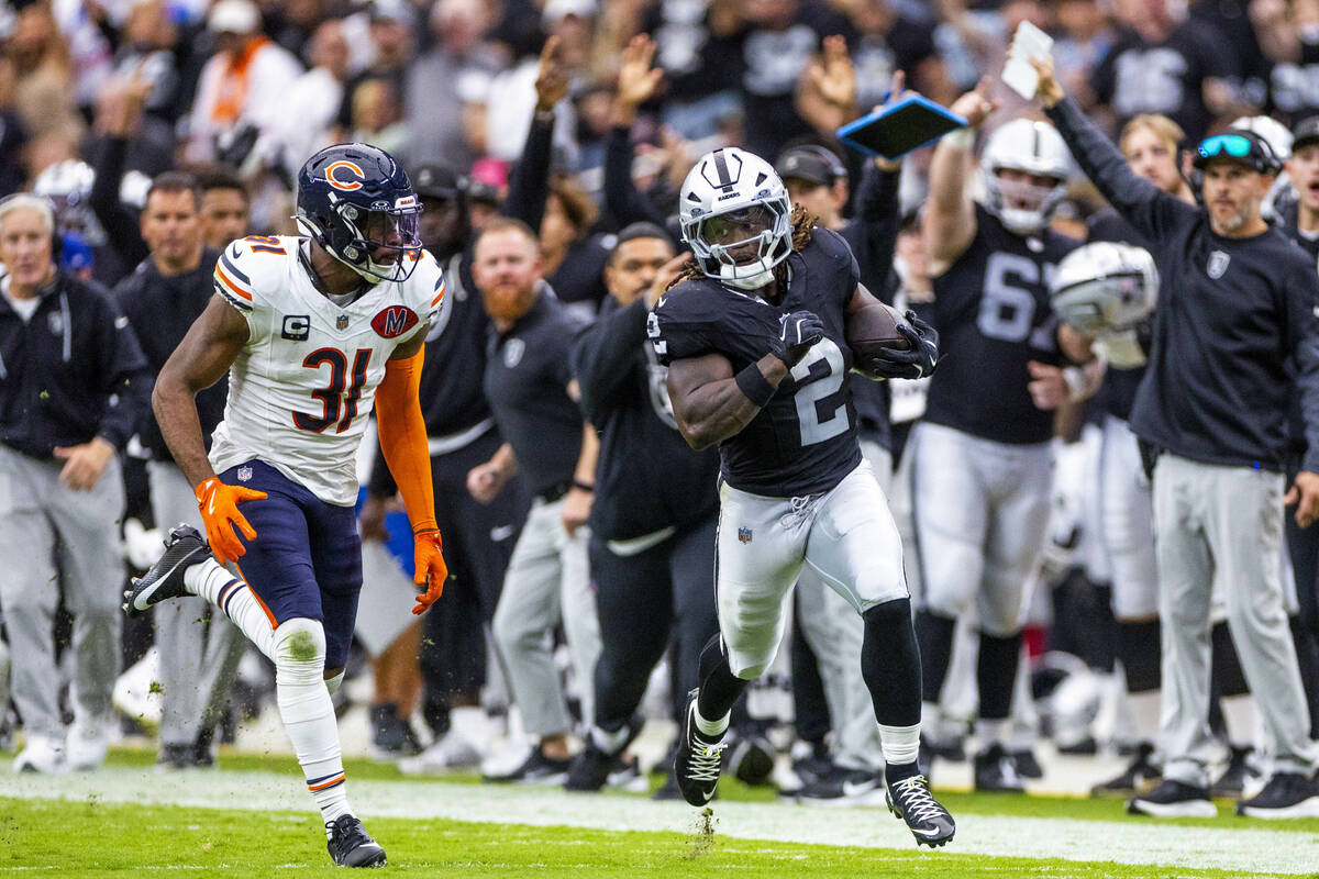 Raiders running back Ashton Jeanty (2) sprints down the sidelines pursued by Chicago Bears free ...