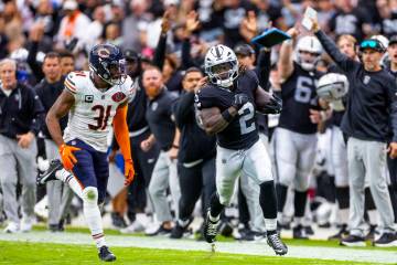 Raiders running back Ashton Jeanty (2) sprints down the sidelines pursued by Chicago Bears free ...