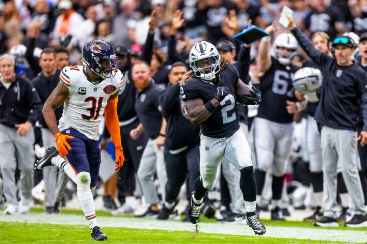 Raiders running back Ashton Jeanty (2) sprints down the sidelines pursued by Chicago Bears free ...