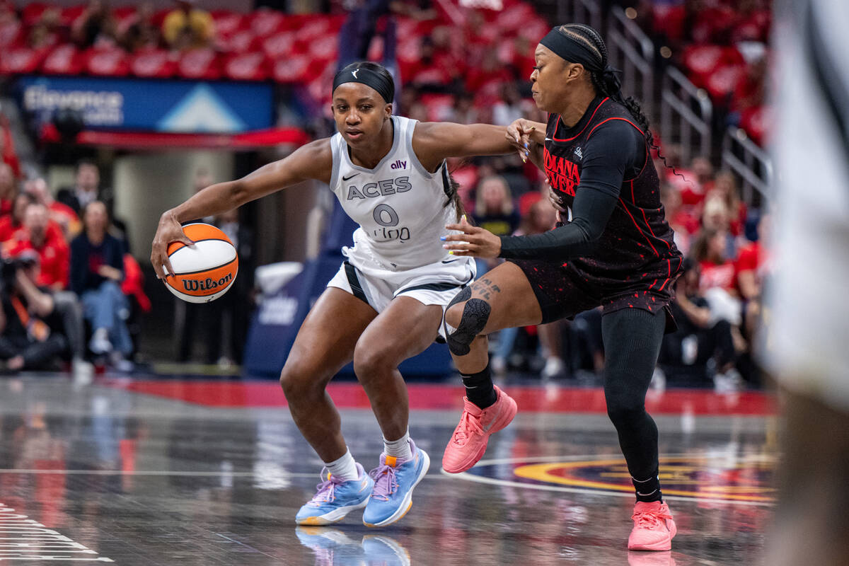 Las Vegas Aces guard Jackie Young (0) drives the ball around the defense of Indiana Fever guard ...