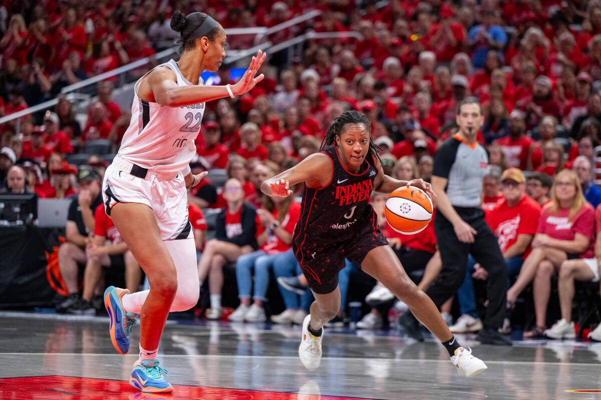 Indiana Fever guard Kelsey Mitchell, front right, drives the ball along the baseline while defe ...