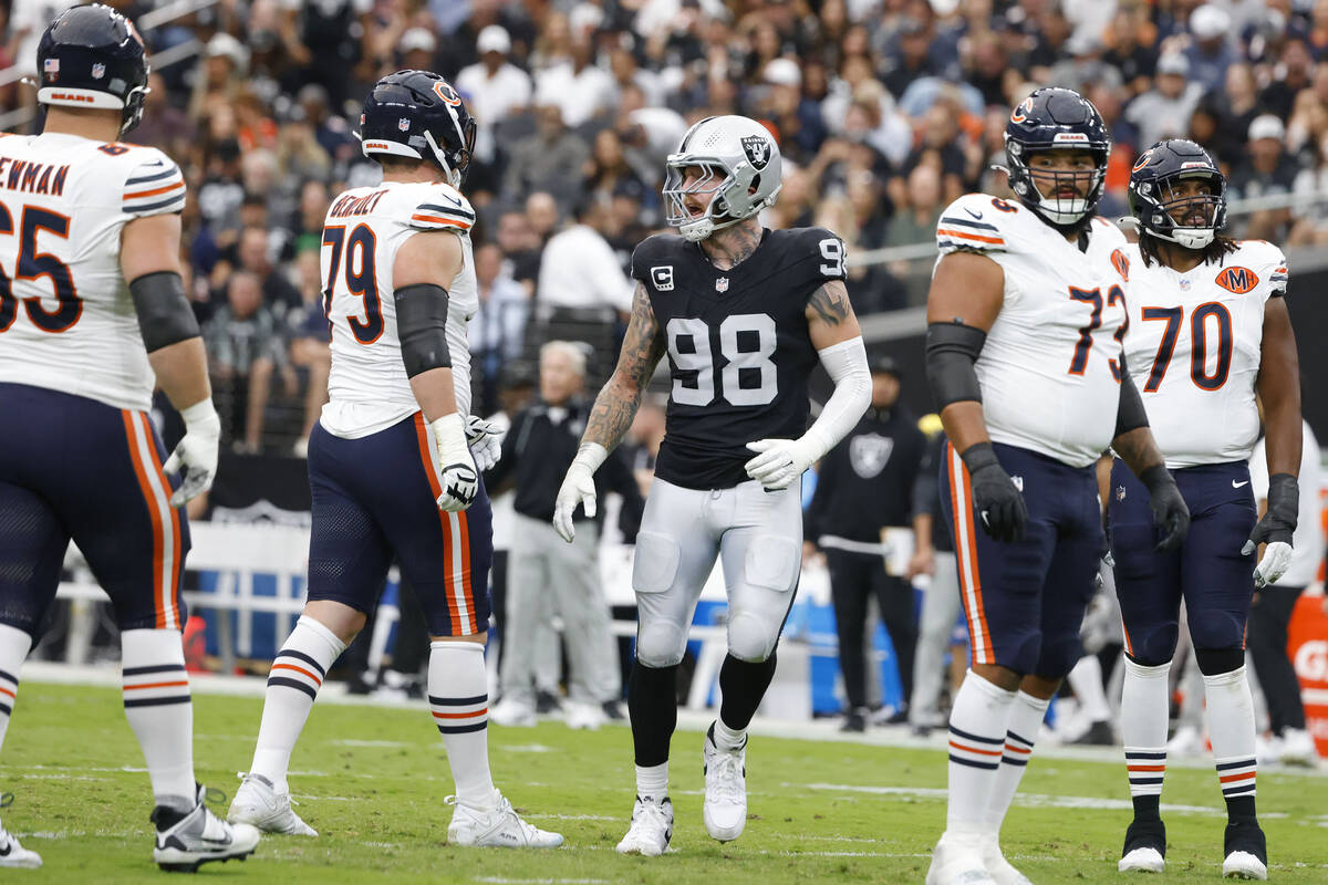 Chicago Bears players as watch as Raiders defensive end Maxx Crosby (98) reacts after blocking ...