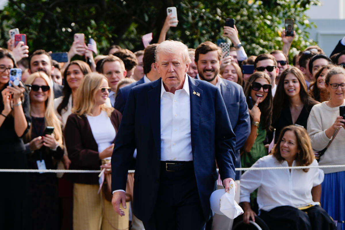 President Donald Trump walks to speak with reporters after greeting supporters before departing ...