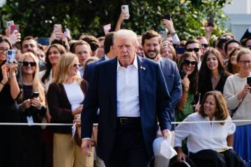 President Donald Trump walks to speak with reporters after greeting supporters before departing ...