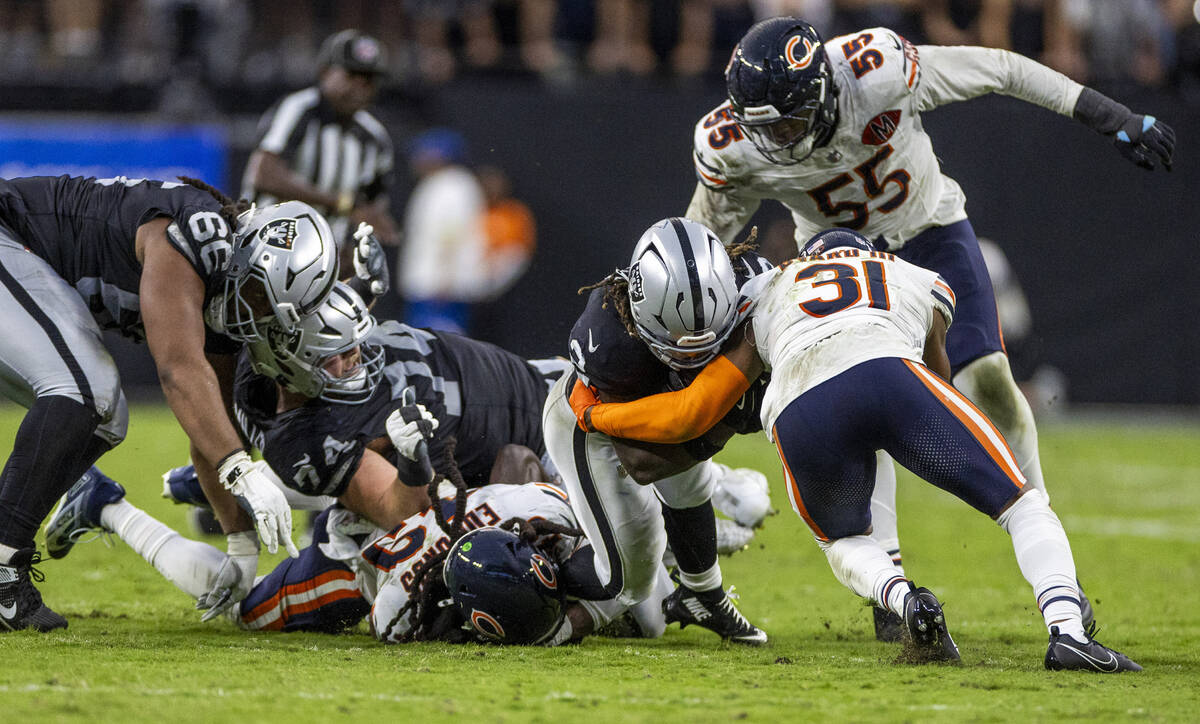 Raiders offensive tackle Kolton Miller (74) gets his leg caught beneath Chicago Bears middle li ...