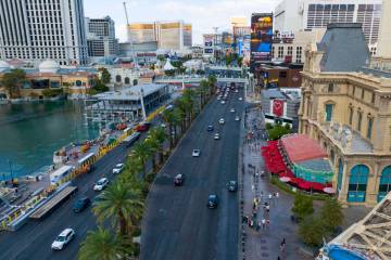 Workers install grandstands, left, in front of the Bellagio Fountains for the 2025 Formula One ...