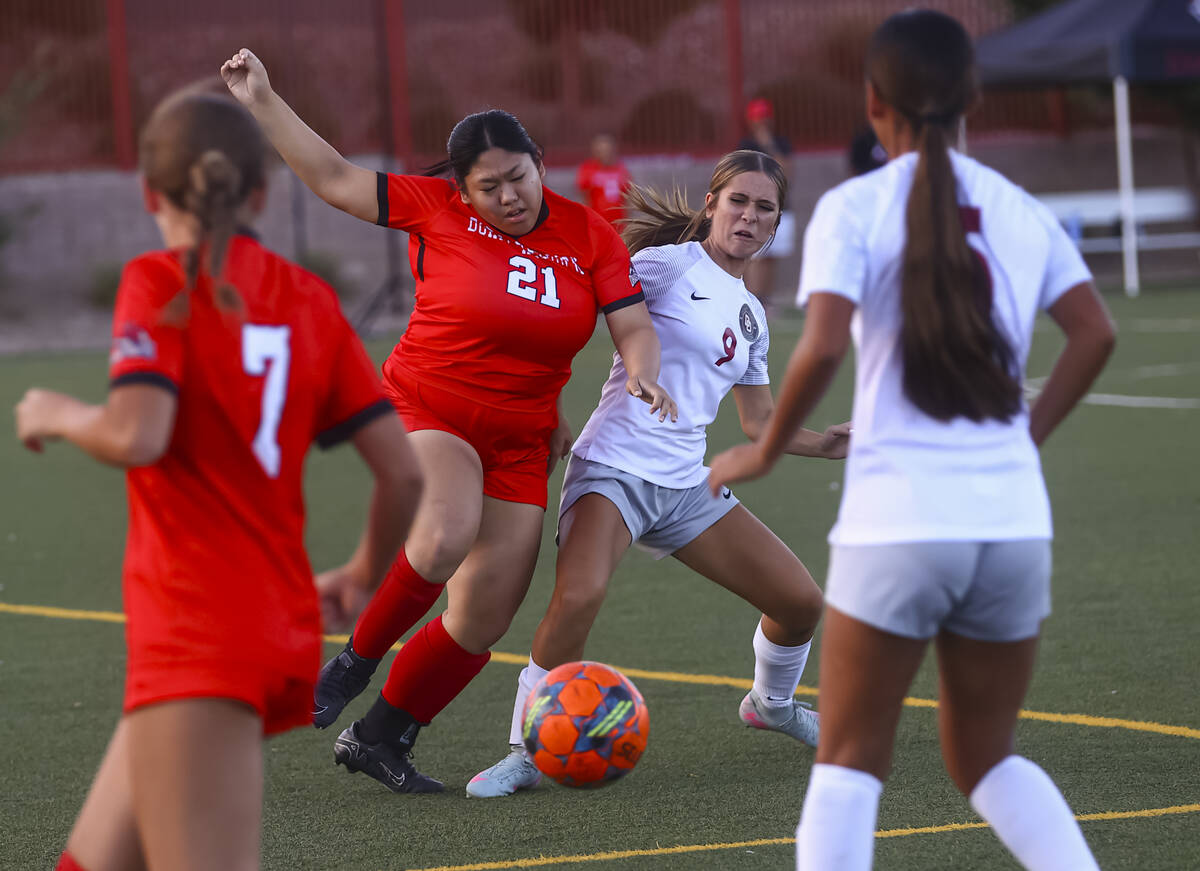 Doral Academy's Jasmine Pinchay (21) kicks the ball under pressure from Desert Oasis' Addison M ...