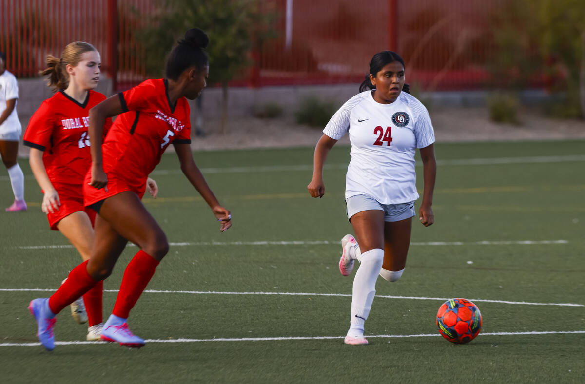 Desert Oasis' Jaelyn Thigpen (24) tries to keep the ball from Doral Academy's Sanyi T ...