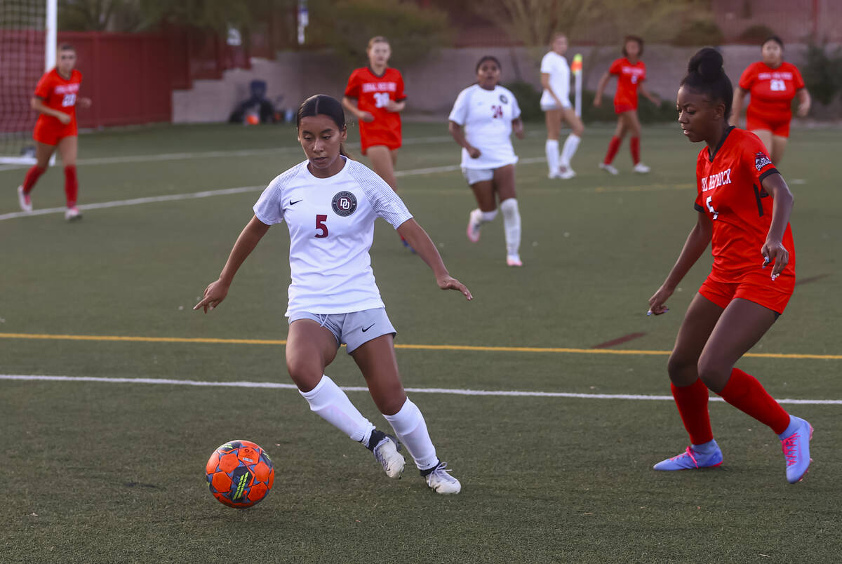 Desert Oasis' Analia Mendonca (5) moves the ball under pressure from Doral Academy's Sanyi Thom ...